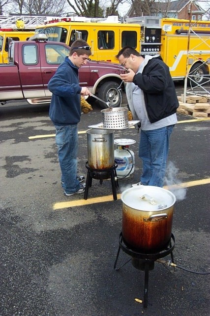 Firefighters Mike Predmore and Bill Wohl, Jr. check the turkey cookers at the annual Xmas lunch